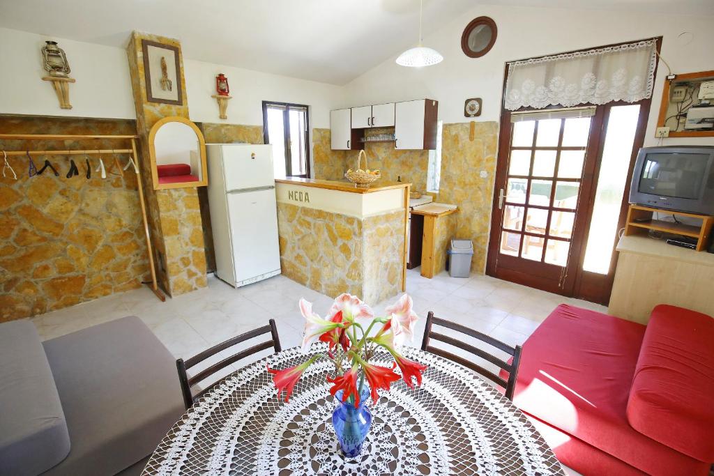 une cuisine et une table avec un vase de fleurs. dans l'établissement House Neda, Dugi Otok, à Sali