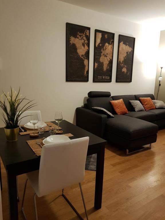 ein Wohnzimmer mit einem Tisch und einem schwarzen Sofa in der Unterkunft Moonflower House in Mailand