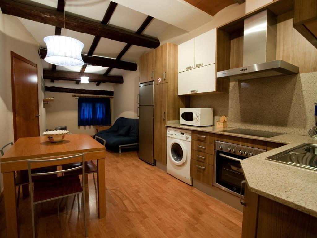 a kitchen with a table and a stove top oven at Apartaments El Jaç in Montblanc