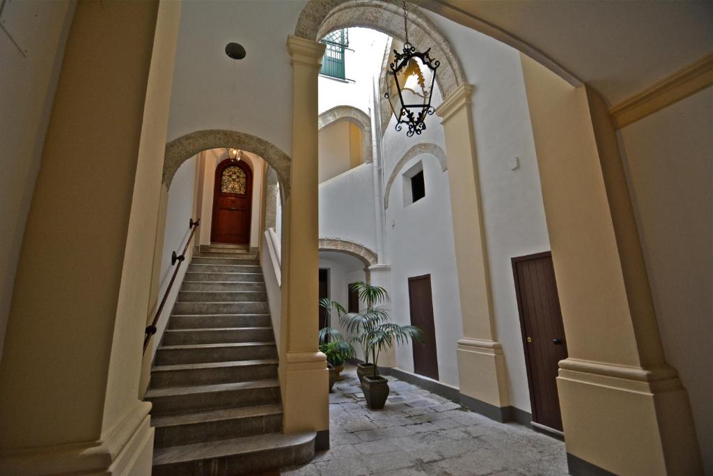 パレルモにあるForesteria della Cattedrale by DomuSicilyの階段とシャンデリアのある建物の廊下
