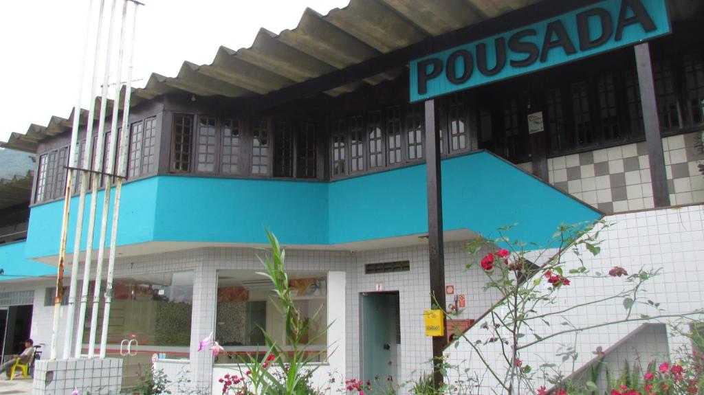 a pole with a street sign in front of a building at Pousada Costa Verde in Caraguatatuba