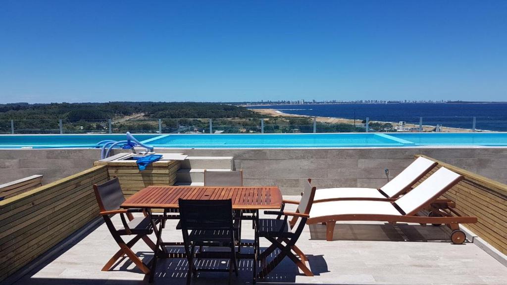 un patio con mesa y sillas en la azotea en Vistas, en Punta del Este