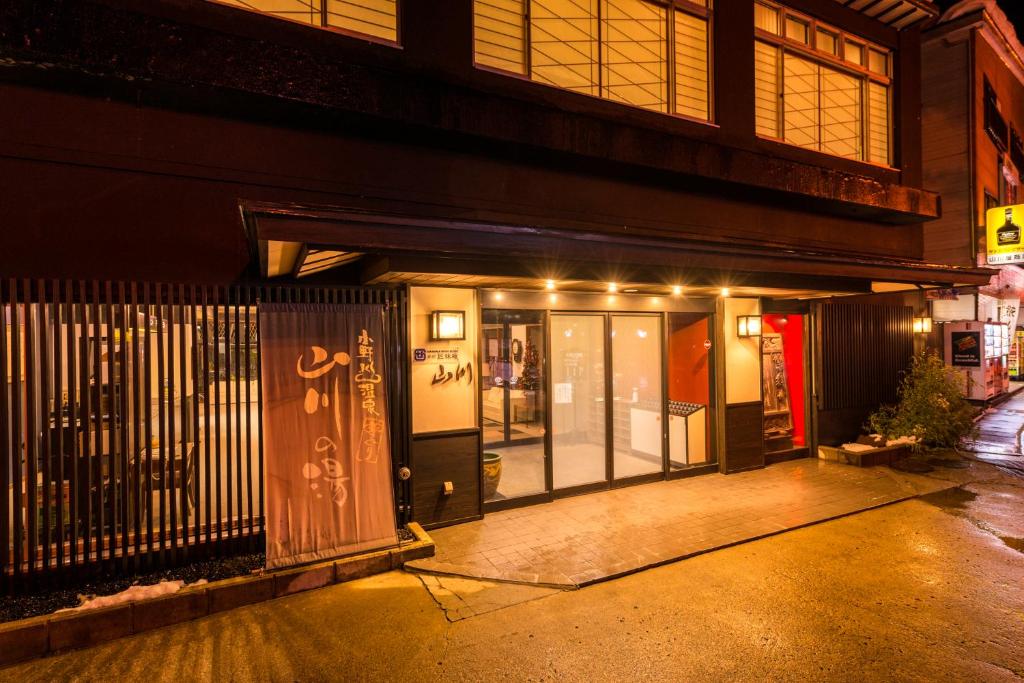 een toegang tot een gebouw 's nachts met verlichting bij Takamiya Ryokan Yamakawa in Yonezawa