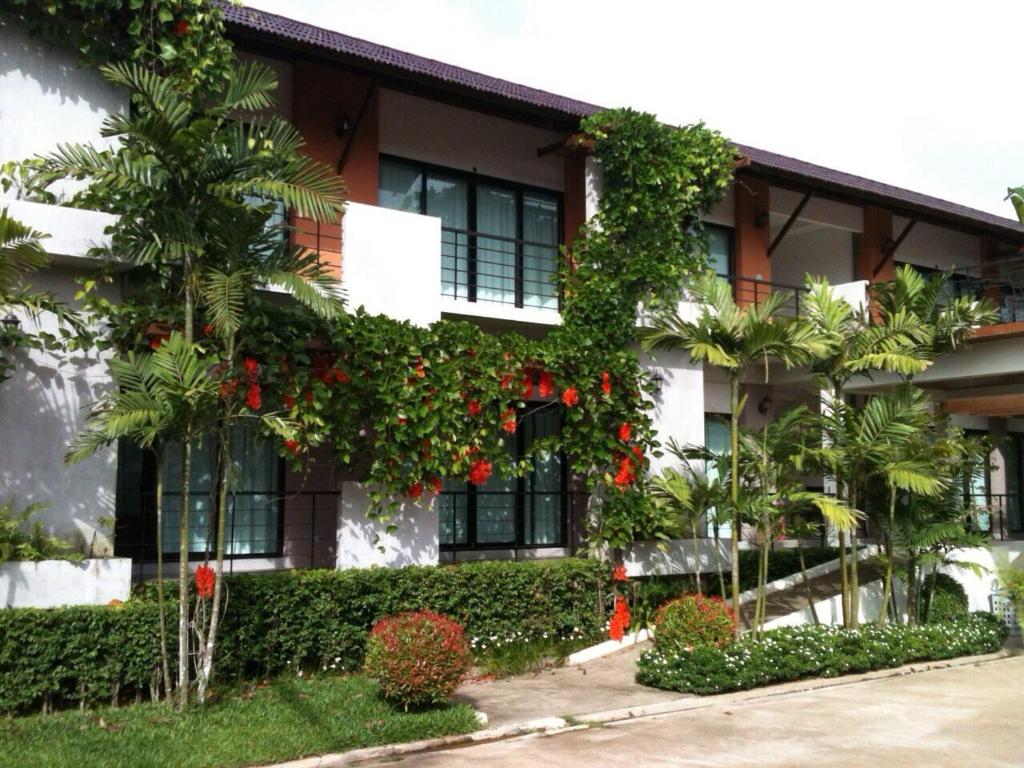 a building with a bunch of red flowers on it at Wassana Sitdharma Guesthouse in Ban Na Pho