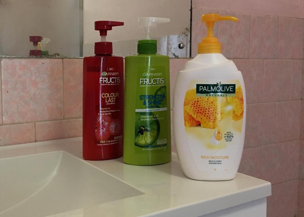 two bottles of cleaning products sitting on a bathroom sink at home in Perth