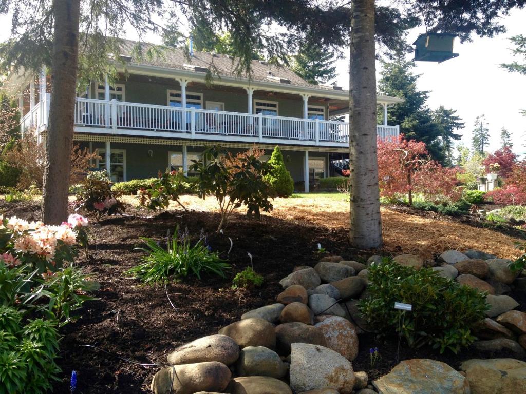 a large house with a yard with rocks at Little Bear Garden View Suites-Hummingbird in Royston