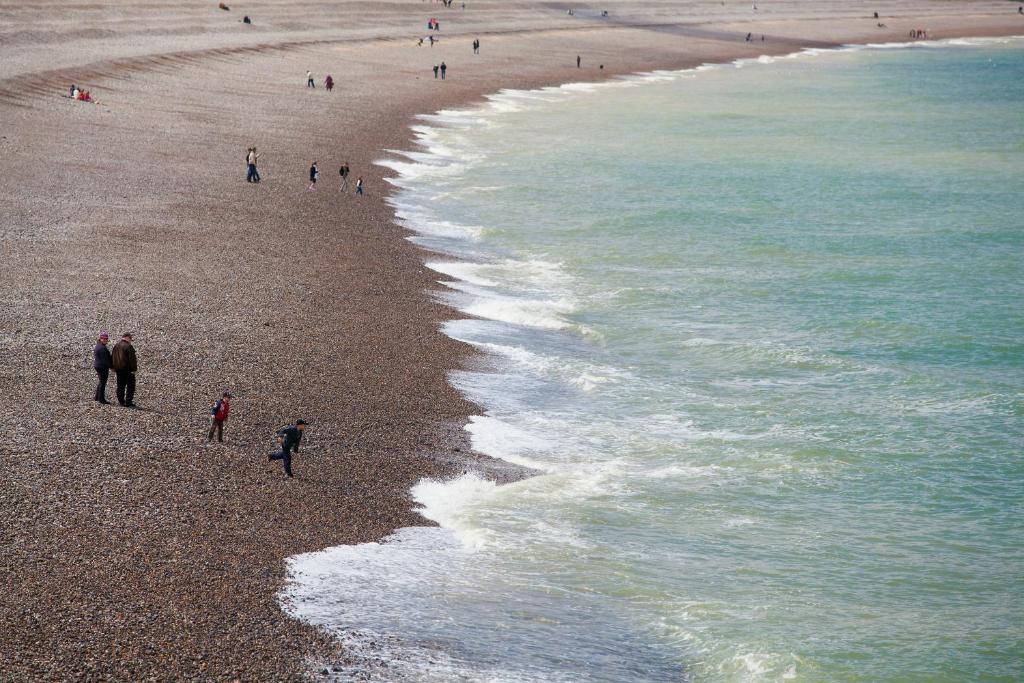 a group of people walking on the beach at Hotel Aguado in Dieppe