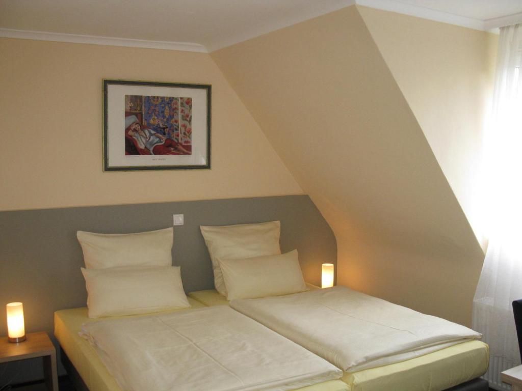 uma cama com duas almofadas num quarto em Löns Hotel Garni em Garbsen