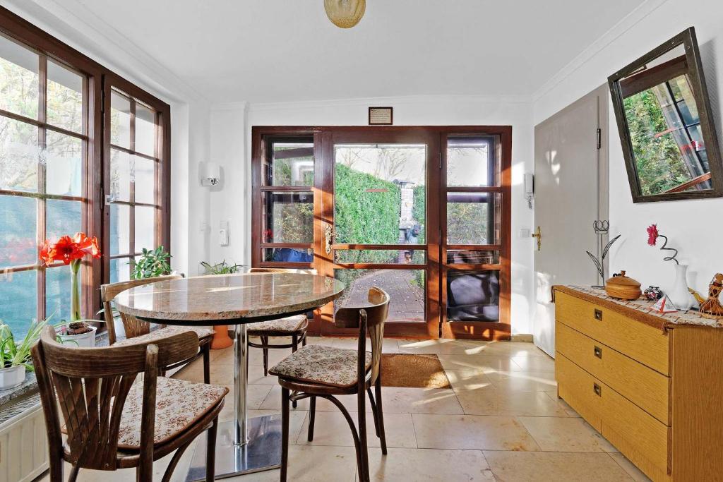 a dining room with a table and chairs and windows at Cottage near centrum, paradise in Berlin