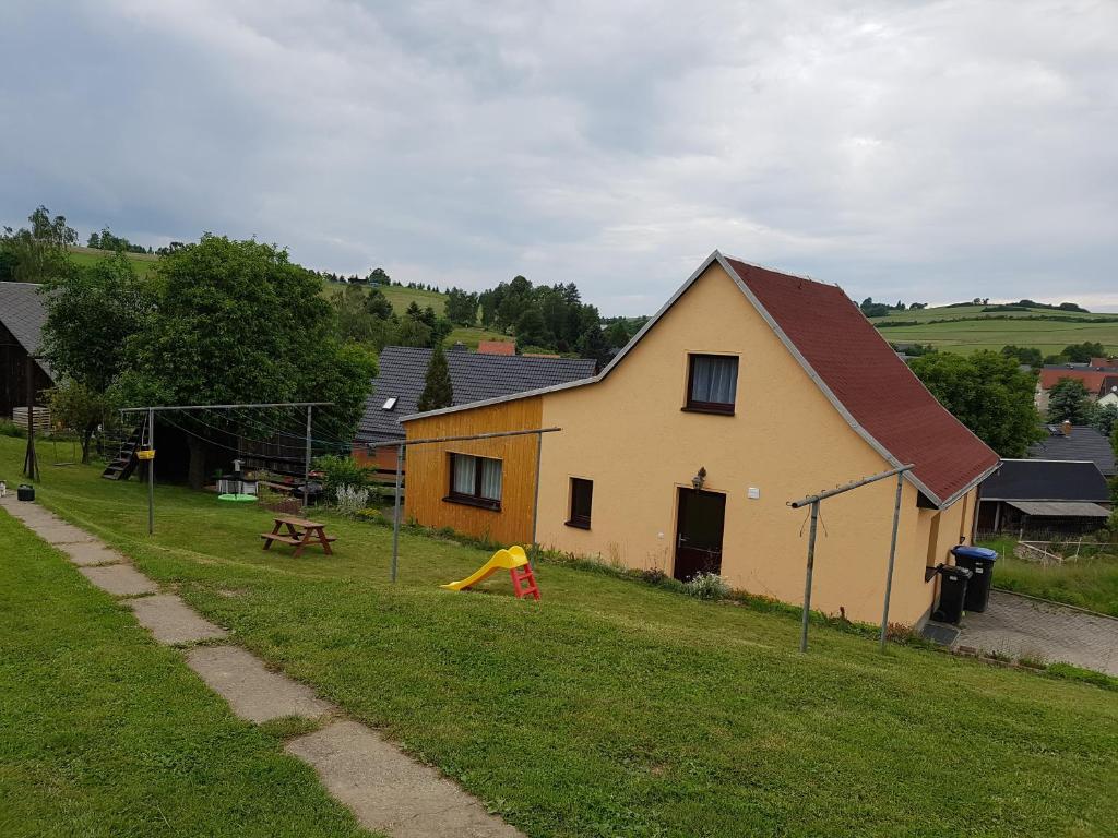 a house with a playground in front of it at Ferienhaus Schaffrath in Hohnstein