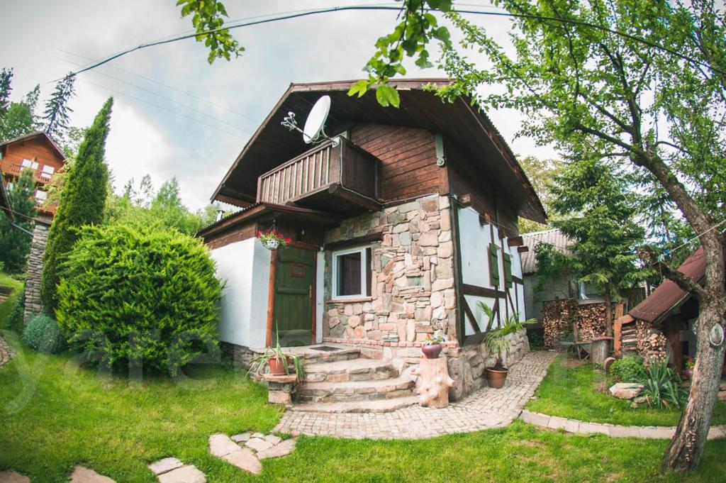 una pequeña casa con una puerta verde en el patio en садиба "У Чубчика", en Yaremche