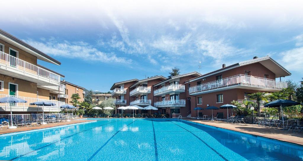 ガルダにあるResidence Villa Rosaの一部のアパートメントビルの前にスイミングプールがあります。