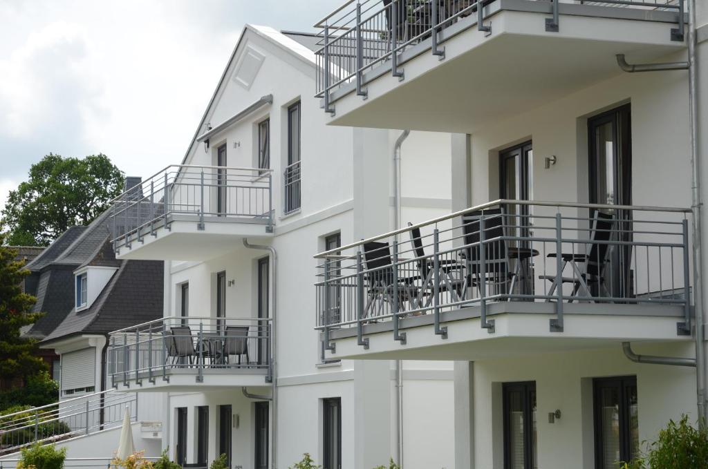 a white building with balconies and tables on it at Residenz Margarete - Apt. 2.3 in Binz