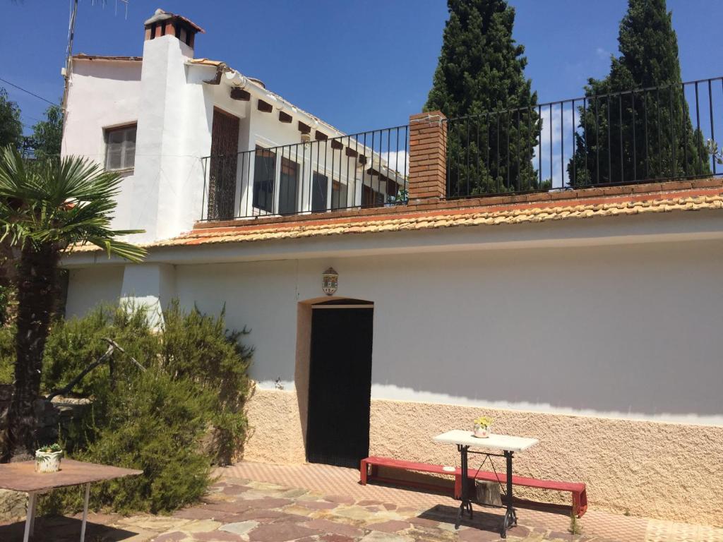 a white house with a black door and two tables at La Casita Peñablanca in Eslida