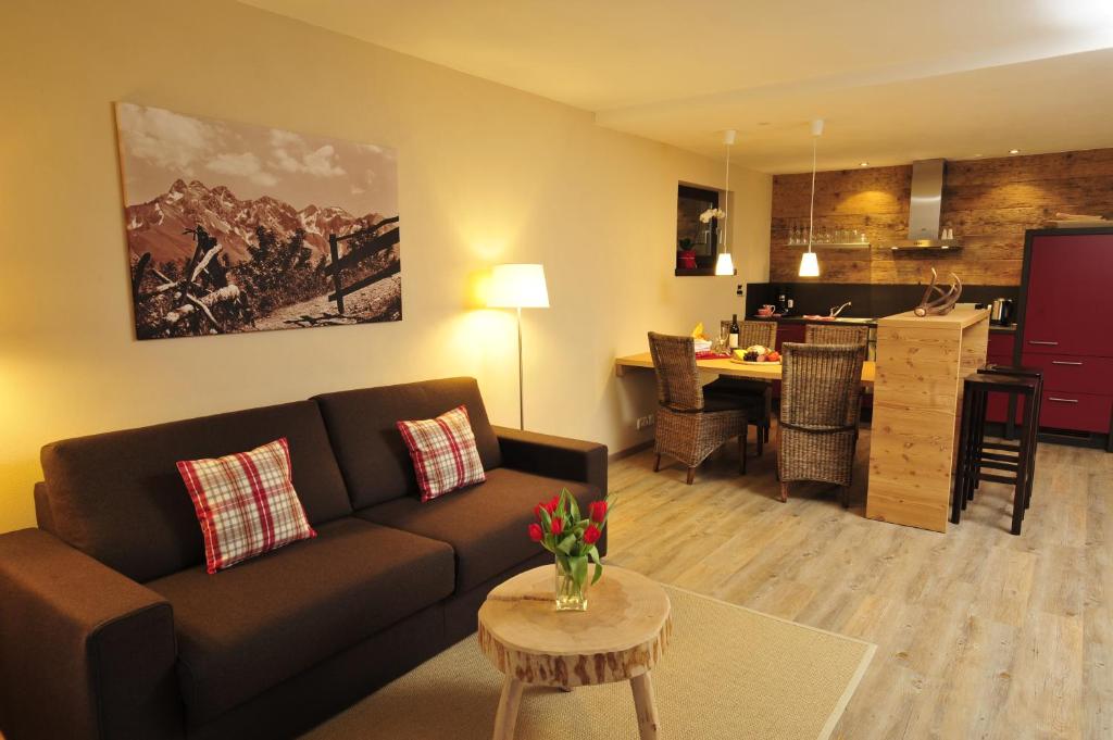 a living room with a couch and a kitchen at Auszeit in Obermaiselstein