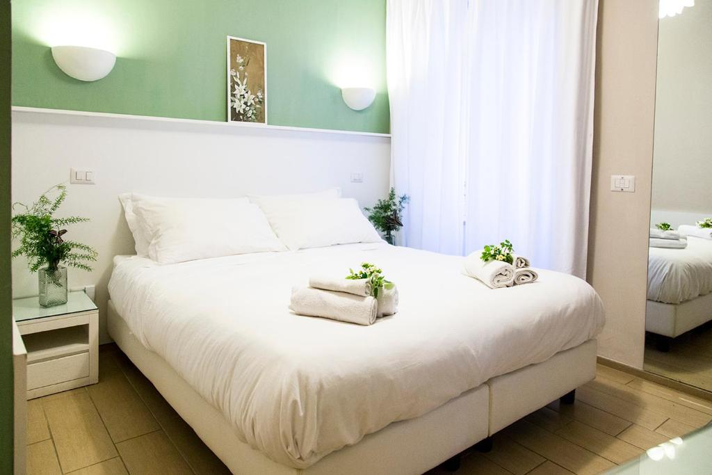 a bedroom with a large white bed with towels on it at B&B Casetta Roma in Rome
