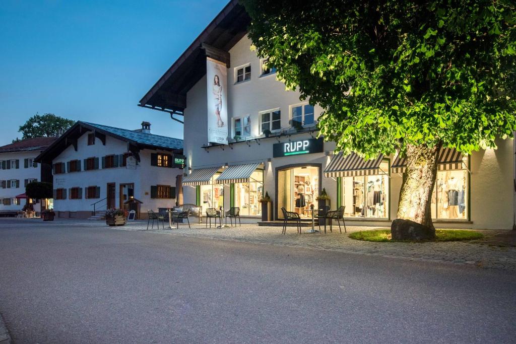 a store with tables and chairs outside of a building at LANDHAUS Mayer - TOP-Ferienwohnungen in Fischen