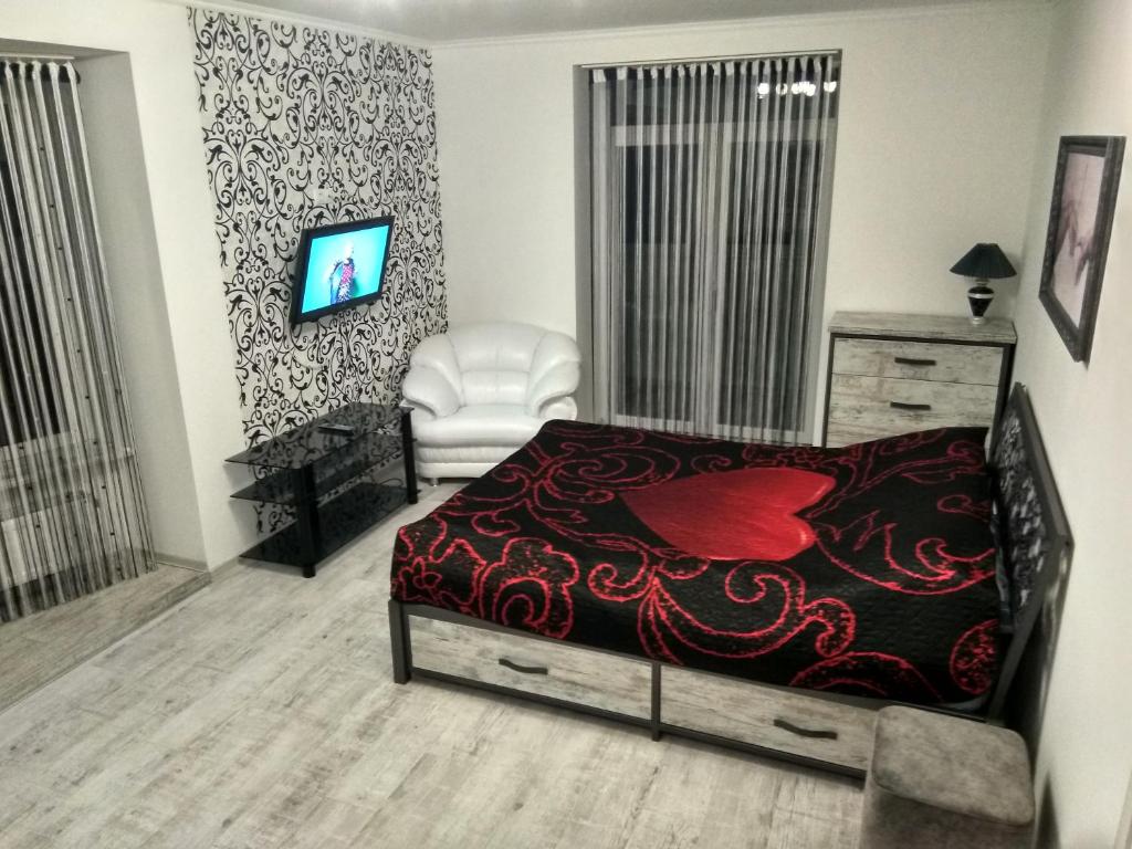 um quarto com uma cama, uma cadeira e uma televisão em Home in Center with jacuzzi em Ivano-Frankivsʼk