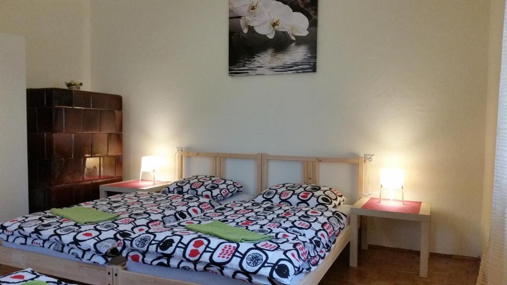 1 dormitorio con 1 cama, 2 mesas y 2 lámparas en Sašo Rooms & Apartments, en Liubliana