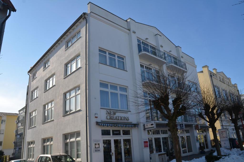 a large white building on a city street at Apartmenthaus Jahreszeiten - Meerblick-Fewo 28 in Binz