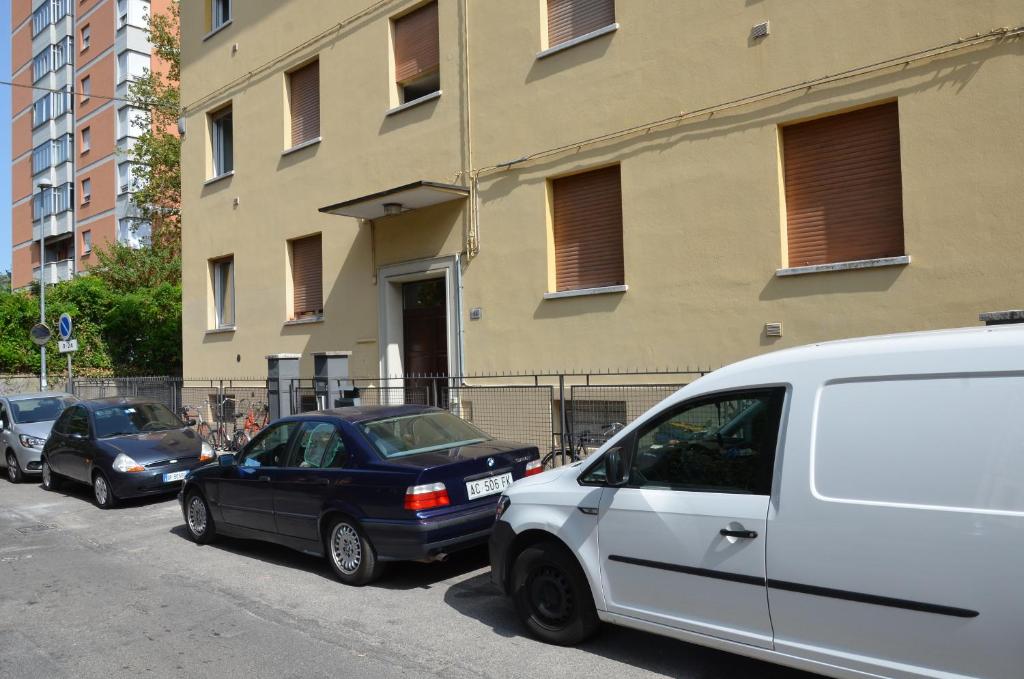 rząd samochodów zaparkowanych przed budynkiem w obiekcie Bologna Dream Apartments w Bolonii