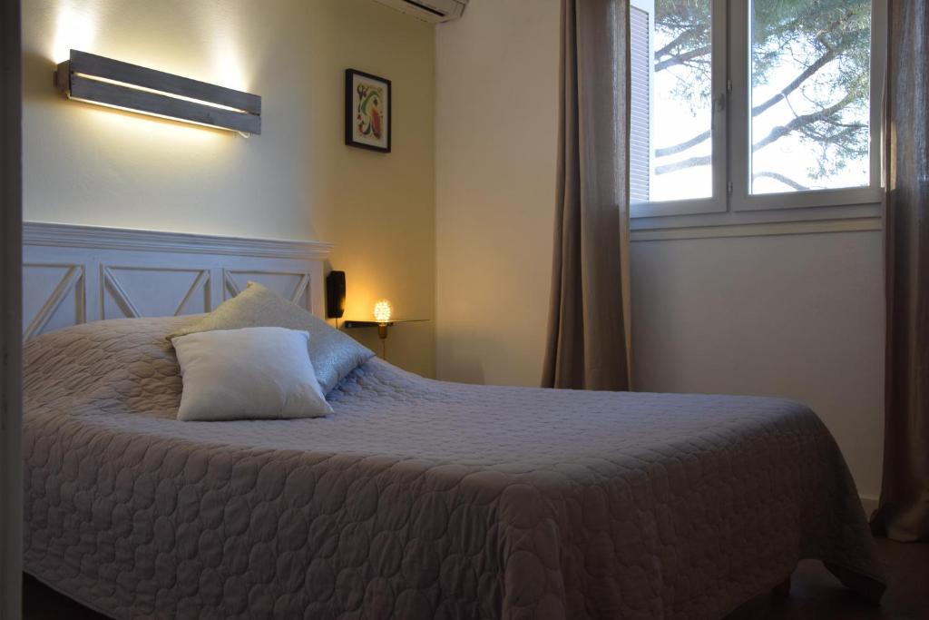Postel nebo postele na pokoji v ubytování Hôtel le Grillon