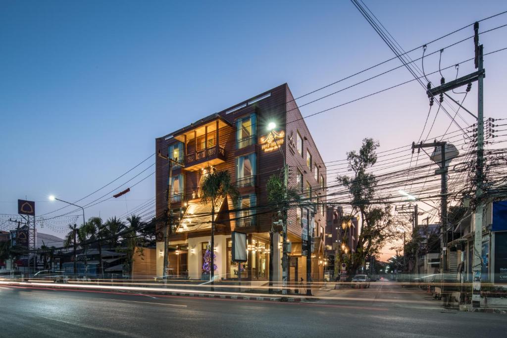 a building on a city street at night at Peak Nimman Prestige Hotel in Chiang Mai