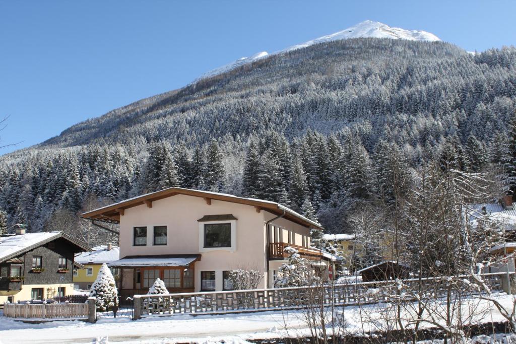 a house in the snow with a mountain in the background at Haus Burgman Bad Gastein - appartement met 4 slaapkamers in Bad Gastein