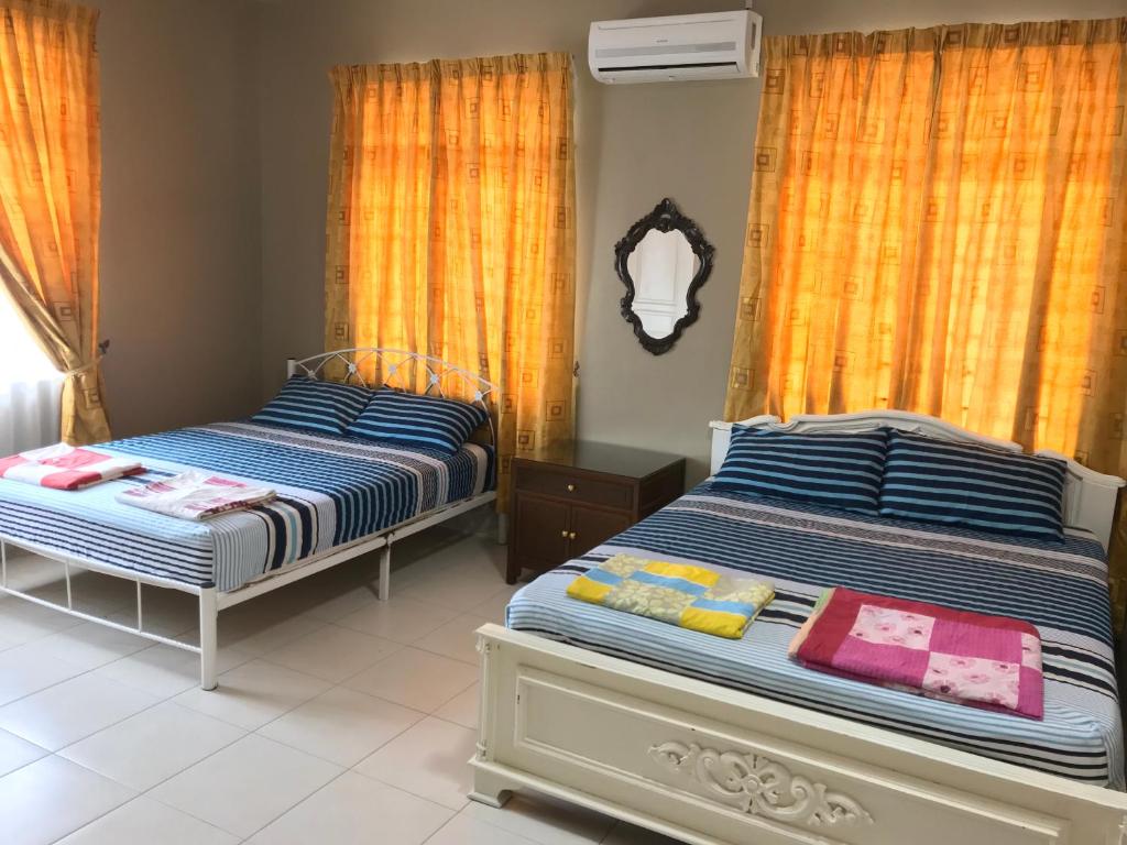 2 letti posti uno accanto all'altro in una camera da letto di Homestay Executive at Town Area for 18 Pax a Malacca