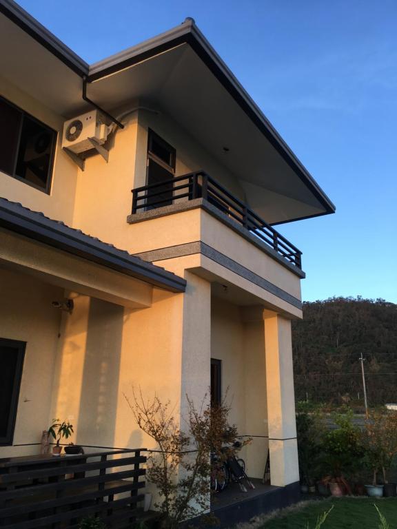 a house with a balcony on top of it at Lan Tian Homestay in Jiaoxi