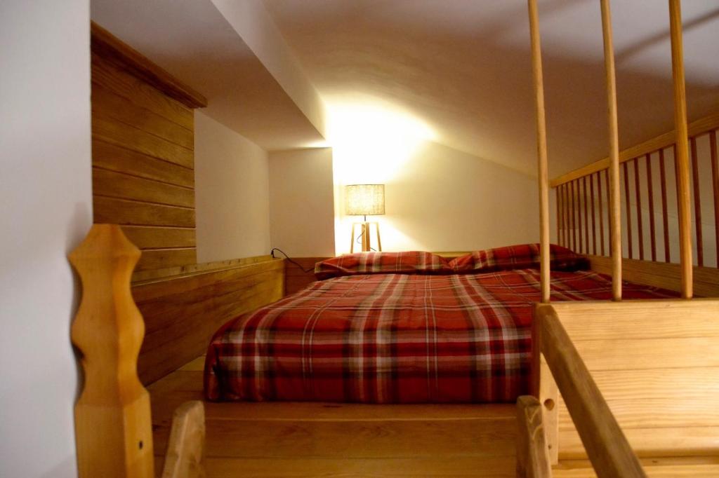 a bedroom with a bed with a red plaid blanket at White Attic in Breuil-Cervinia