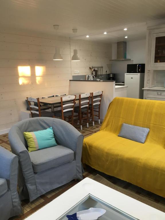 - un salon avec un canapé, des chaises et une table dans l'établissement Maison Bord de Mer au Vieil 3 étoiles, à Noirmoutier-en-l'lle