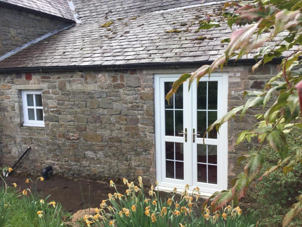 a stone house with a white window at The Snug @ Corry Cottage in Haltwhistle