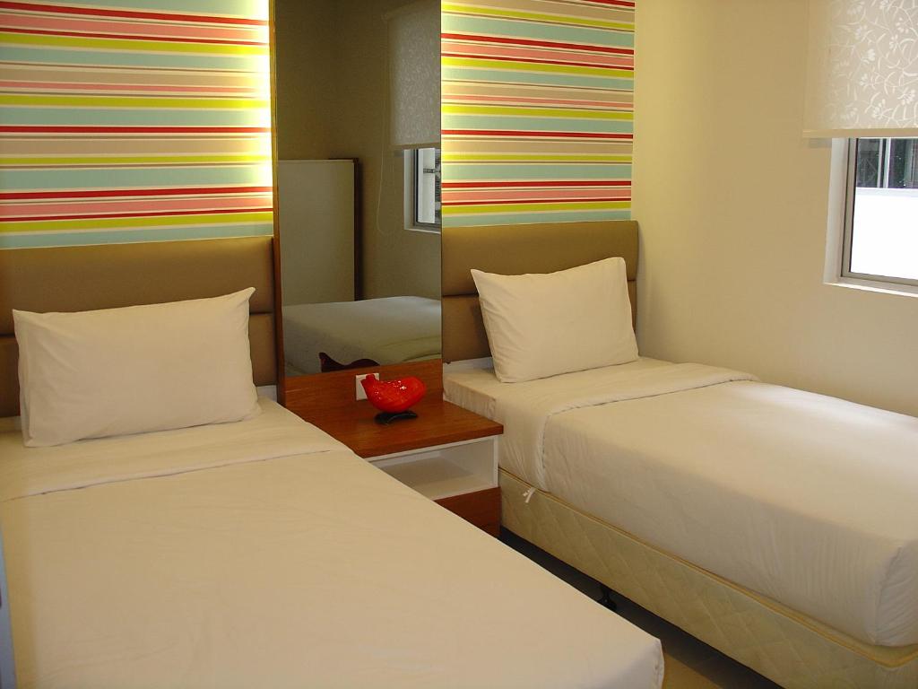 a room with two beds and a colorful wall at Duta Hotel & Residence in Kuala Lumpur