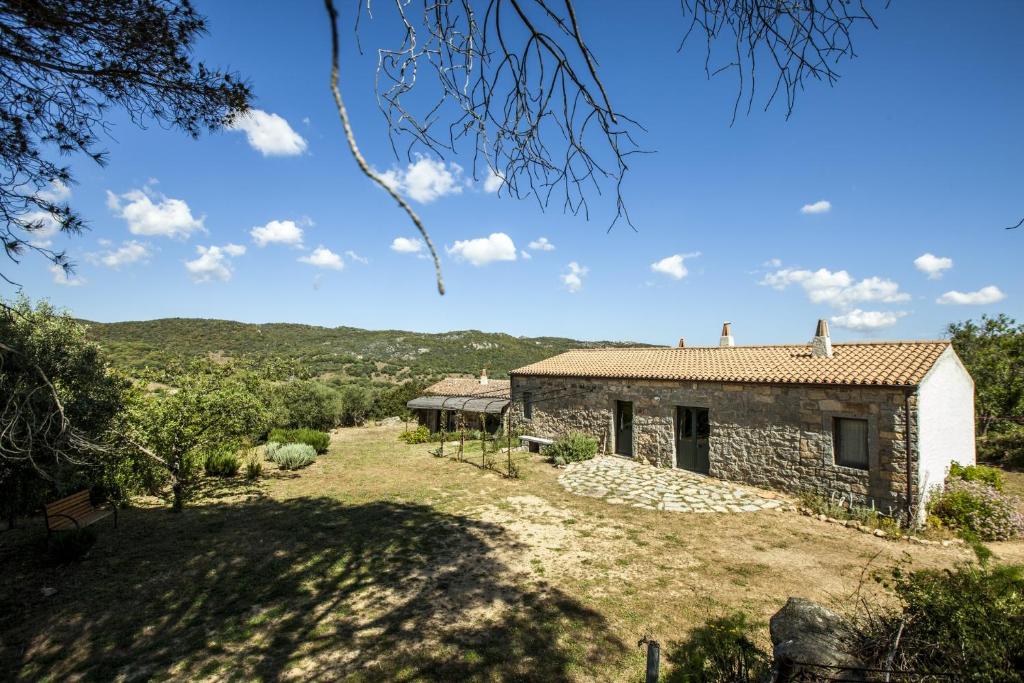 an external view of a stone house with a yard at La Casedda in Luogosanto