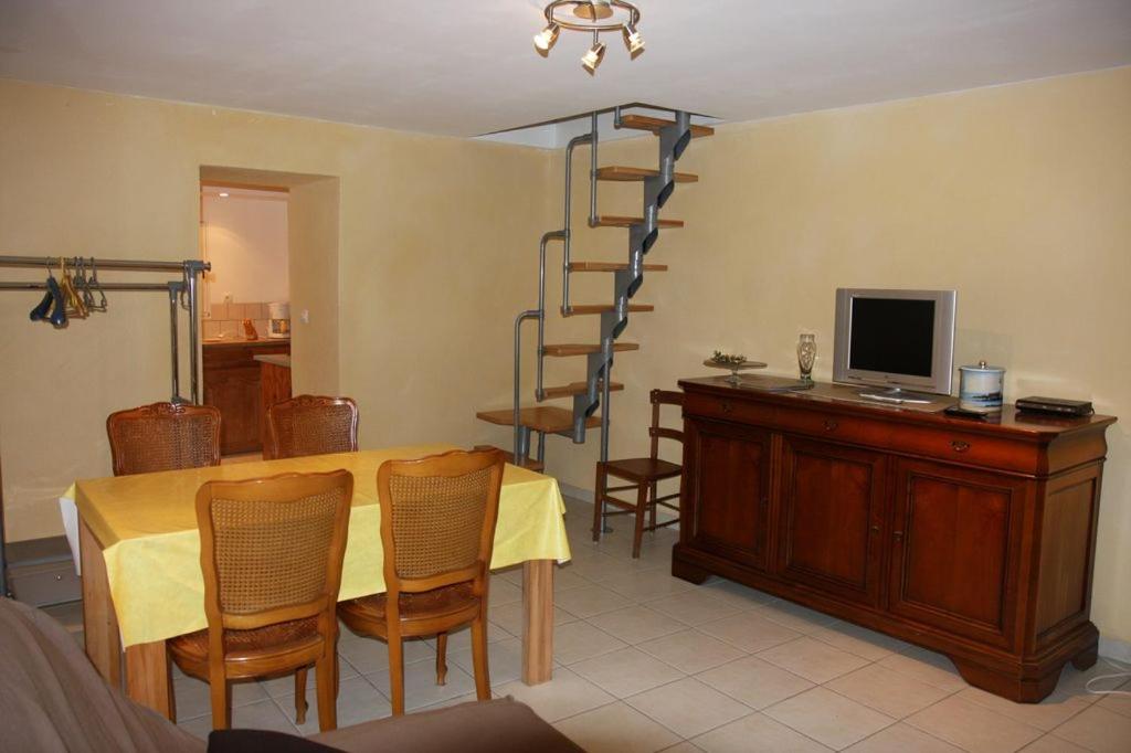 uma sala de jantar com uma mesa e uma escada em espiral em les Jéhans em Chateauroux-les-Alpes