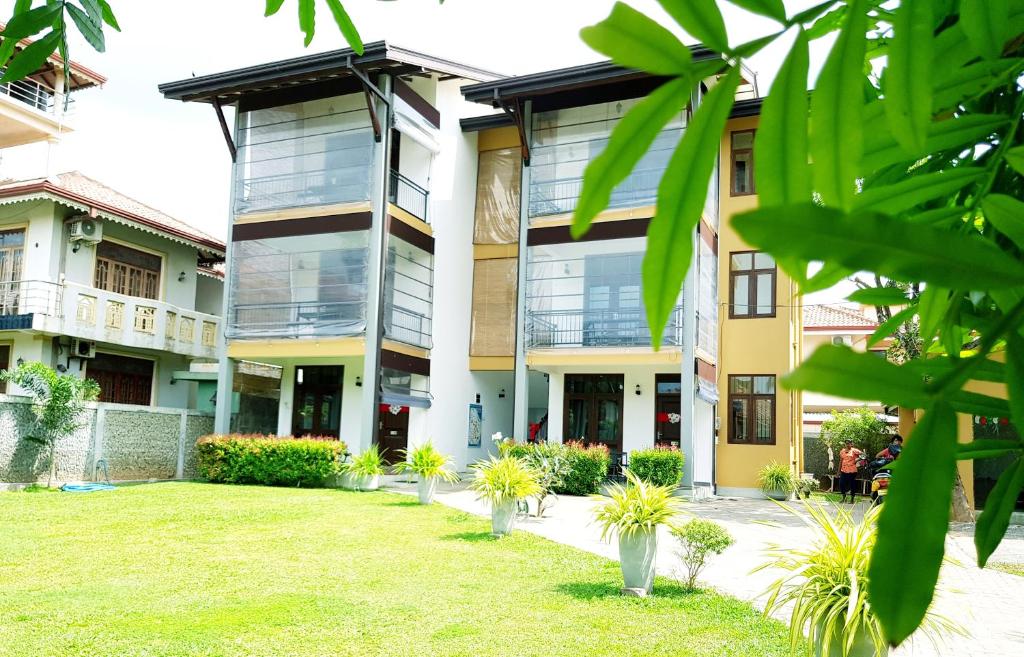 a building with a lawn in front of it at Sea Breeze Deluxe Inn in Negombo
