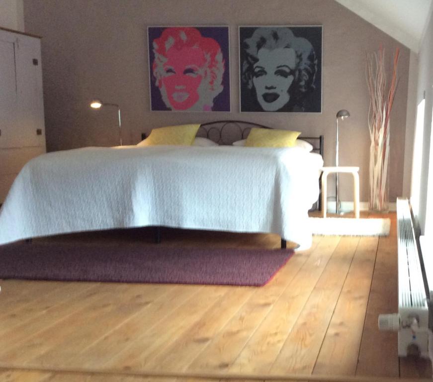 una camera con letto e pavimento in legno di LOFTvorSYLT a Friedrichstadt