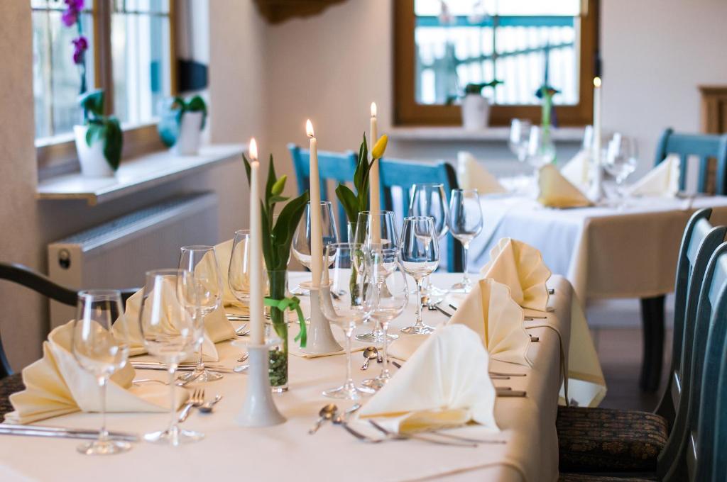 バート・ブラームバッハにあるLandhotel Jungbrunnenの白いテーブルクロスとキャンドルが掛けられたテーブル