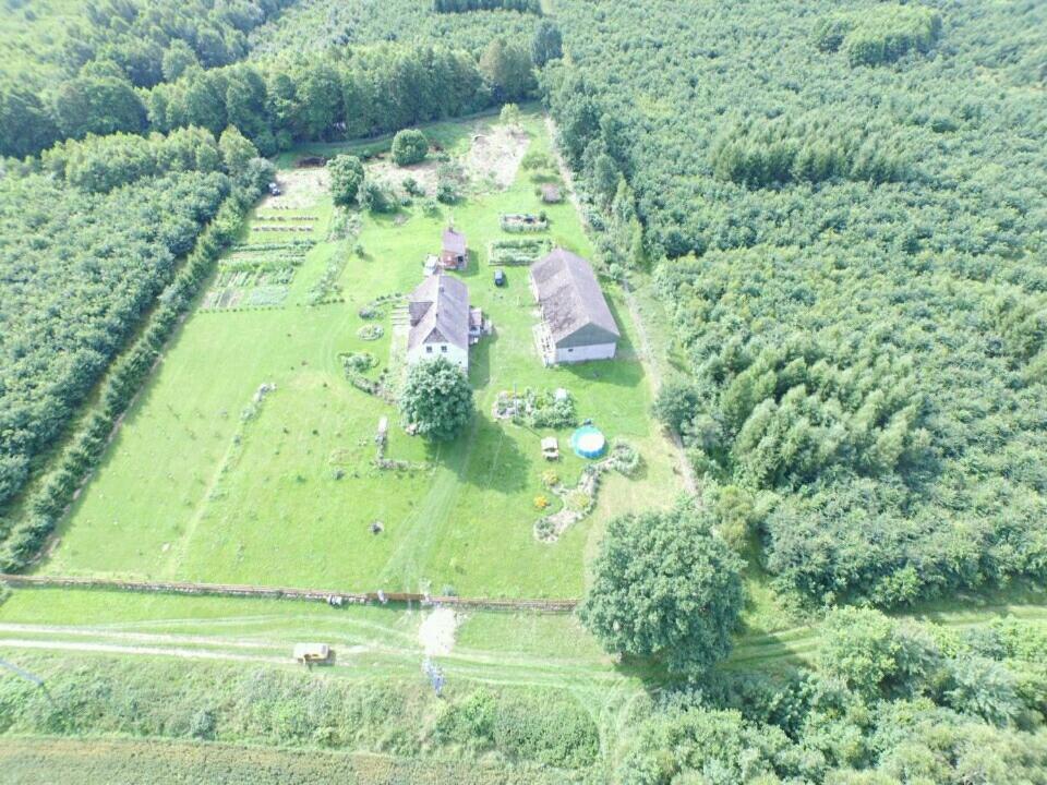 an aerial view of a house in a field at Agroturystyczny Dom Na Skraju Lasu in Sławoborze