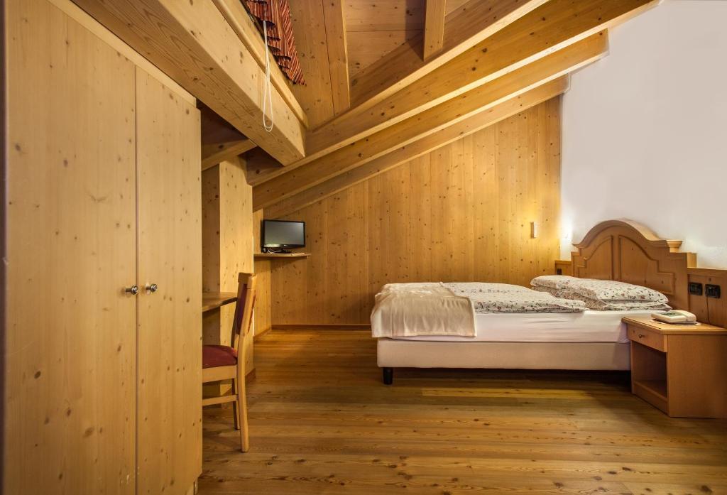 um quarto com uma cama e um tecto de madeira em Hotel Pedranzini em Santa Caterina di Valfurva