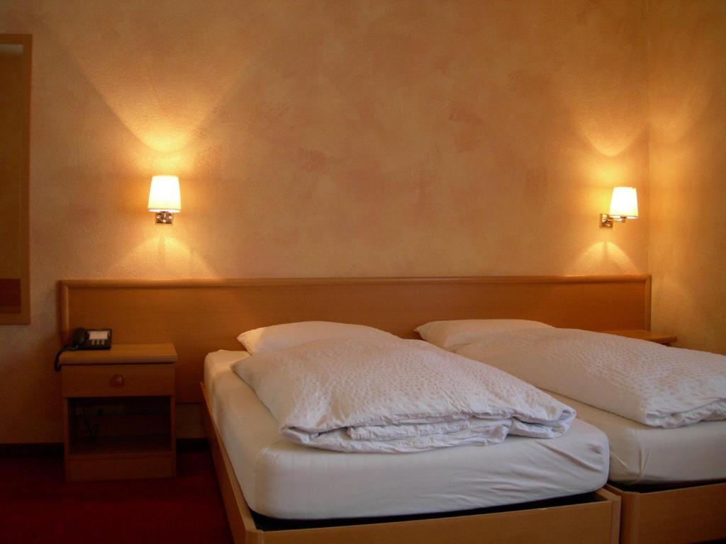 Postel nebo postele na pokoji v ubytování Hotel Crystal Interlaken