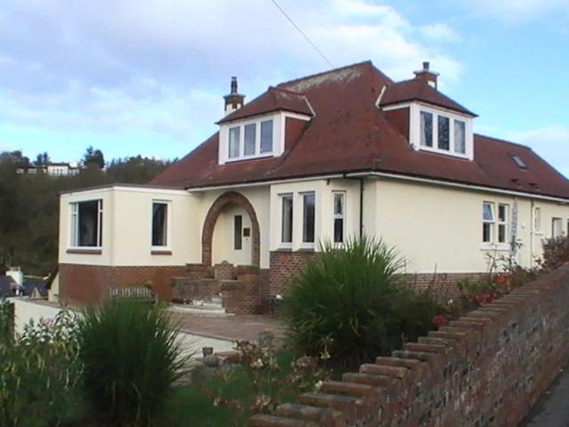 uma grande casa branca com um telhado vermelho em Blinkbonnie Guest House em Portpatrick