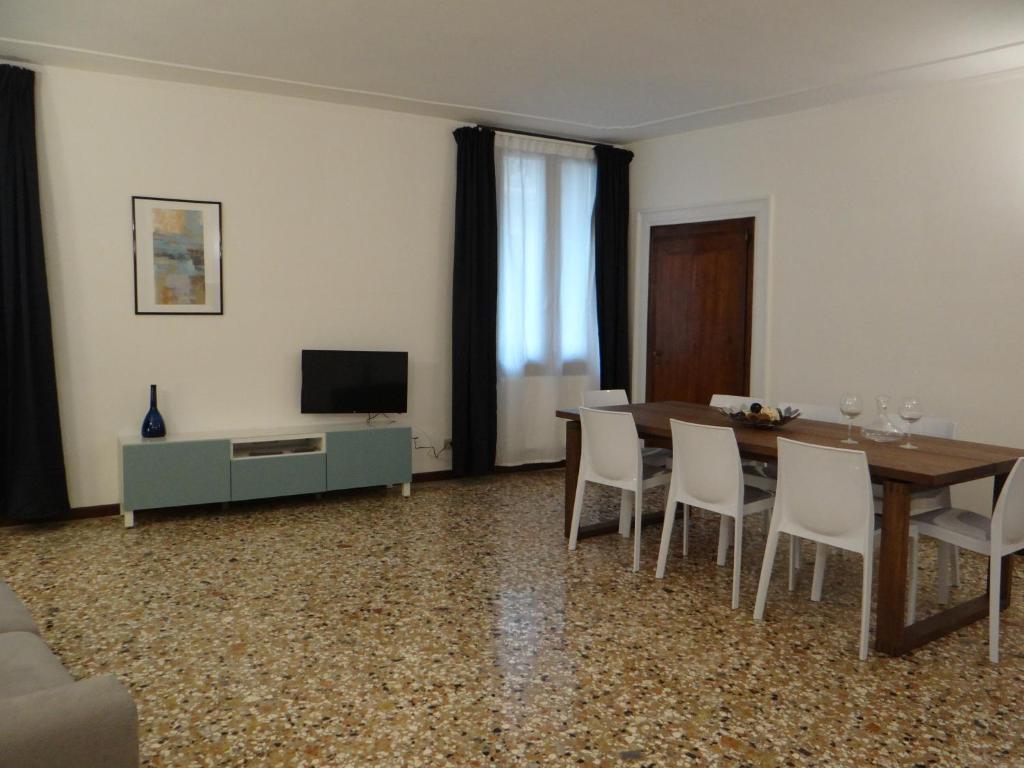 a living room with a table and chairs and a television at Palazzo Boldù - Ca' Colombina in Venice