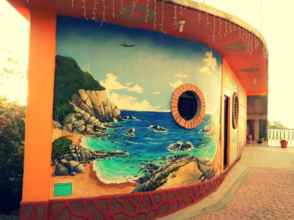 een muurschildering van de oceaan aan de zijkant van een gebouw bij La Casita De Marlen in Puerto Ángel