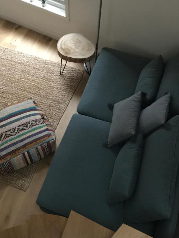 un sofá azul con almohadas en la sala de estar en Mooi Genieten, en Middelburg