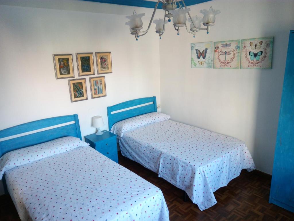 2 camas en una habitación de color azul y blanco en Como en tu propia casa en Granada