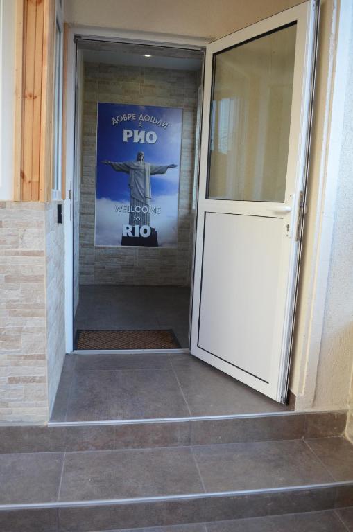 eine Tür zu einem Gebäude mit einem Schild an der Wand in der Unterkunft Rio rooms (стаи за гости) in Schumen