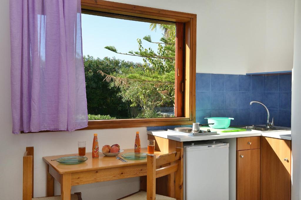 a kitchen with a small table and a window at San Antonio Apartments in Kolymvari