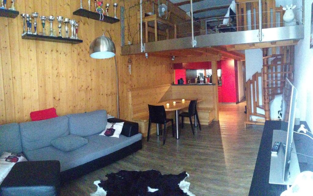 ein Wohnzimmer mit einer Couch und einem Tisch mit Stühlen in der Unterkunft Flaine Forum i1 Cassiopée Duplex Mezzanines & Terrasse in Flaine